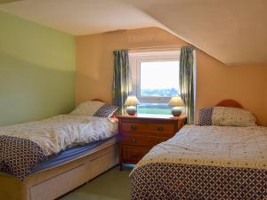 a bedroom with two beds and a window at Shingle Cottage in Seascale