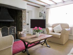 a living room with a couch and a fireplace at Chaplands in Beaford