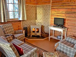 a living room with a fireplace in a log cabin at Moorside Lodge in Soutergate