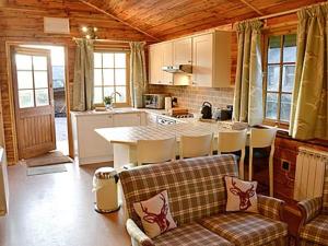 a kitchen with a table and chairs in a room at Moorside Lodge in Soutergate