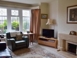 a living room with a tv and a chair and a fireplace at Ivy House in Saint Annes on the Sea