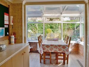 a kitchen with a table with chairs and a window at Ivy House in Saint Annes on the Sea