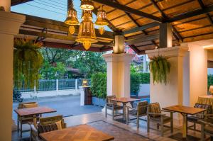 a patio with tables and chairs and a chandelier at Luck Thai Hotel in Chiang Mai