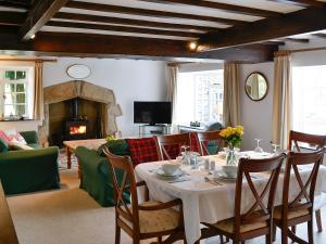 a dining room with a table and a fireplace at East House Farm in Beckermonds