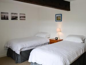dwa łóżka siedzące obok siebie w pokoju w obiekcie East House Farm w mieście Beckermonds