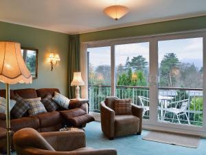 a living room with a couch and chairs and a balcony at Lake View in Bowness-on-Windermere