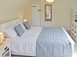 a bedroom with a white bed with two pillows at Watersmeet in Looe
