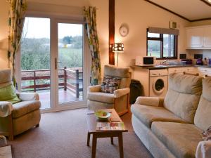 a living room with a couch and a table and a kitchen at Catbank in Bridekirk