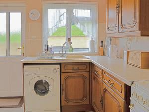 a kitchen with a sink and a washing machine at Abbotts Ball Farm in Potterne