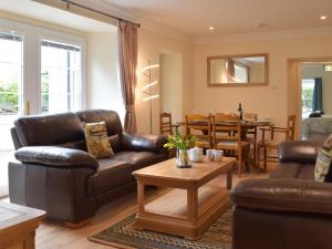 sala de estar con muebles de cuero y mesa en Victoria House - Uk13380, en Llanstephan