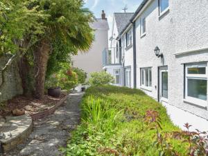 un pequeño callejón entre dos casas con plantas en Victoria House - Uk13380, en Llanstephan