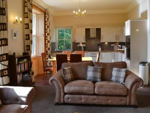 a living room with a couch and a kitchen at Langdale Crag in Grasmere