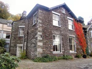 a brick building with white windows and red ivy at Langdale Crag in Grasmere