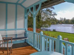 a blue porch with a view of the water at Leisure Hour in Wroxham