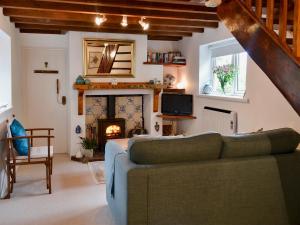 a living room with a couch and a fireplace at Oak Apple Cottage in Upottery