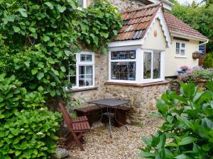 a table and chairs in front of a house at Oak Apple Cottage in Upottery