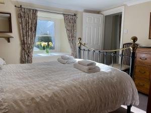 ein Schlafzimmer mit einem Bett mit Handtüchern darauf in der Unterkunft Bunbury Cottage in Keswick