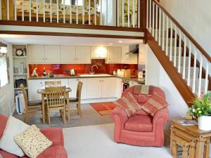 a kitchen and a living room with a staircase at Chywood Barn in Carleen