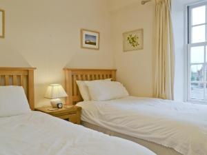 1 dormitorio con 2 camas y ventana en Trentham Cottage, en Snettisham
