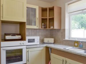 a kitchen with a sink and a microwave at Jasper in Broadstone
