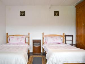 two beds in a room with white walls at Ty-gwyn in Brondini