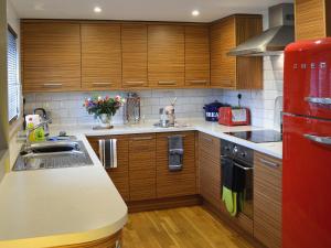 a kitchen with wooden cabinets and a red refrigerator at Dyji in St Just