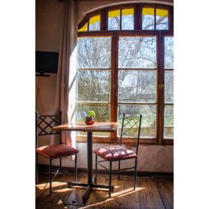 una mesa y dos sillas frente a una ventana en Hostal Los Castaños, en San Alfonso