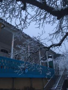 uma casa com uma cerca azul na neve em Guesthouse em Oni