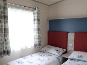 a bedroom with two twin beds and a window at The Retreat in Budleigh Salterton