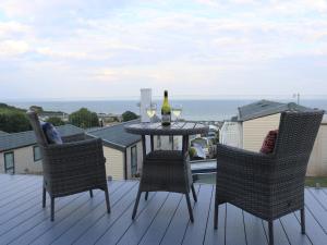 a table with two chairs and a glass of wine on a deck at The Retreat in Budleigh Salterton