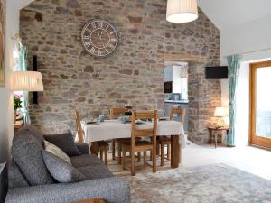 a living room with a table and a stone wall at Bramble Cottage Mountain Retreat in Twyn Llanan