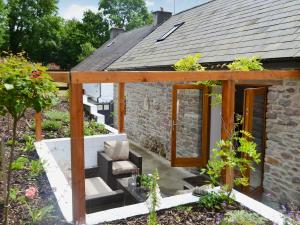 a garden with a stone house with a patio at Bramble Cottage Mountain Retreat in Twyn Llanan