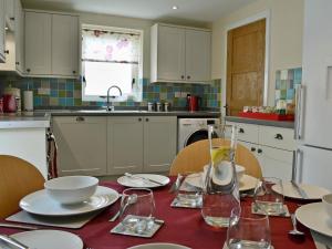 a kitchen with a table with plates and glasses on it at Oak House in Rhewl