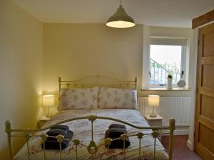 a bedroom with a bed with two lamps and a window at Oak House in Rhewl