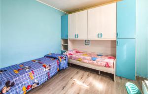 Cet hébergement comprend 2 lits dans une chambre dotée de murs bleus et de placards blancs. dans l'établissement 2 Bedroom Cozy Home In Serra San Bruno, à Serra San Bruno