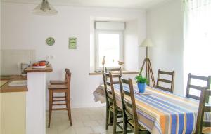una cocina con mesa y sillas y una cocina con mesa y barra. en Gorgeous Home In Quemper Guezennec With Wifi, en Quemper-Guézennec