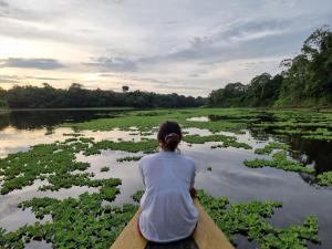 una mujer sentada en un barco en un río con lirios en Amazon Golden Snake Lodge, en Santa Teresa