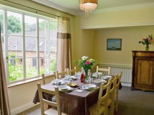 a dining room table with chairs and a large window at The Old Barn - 28971 in Selstead