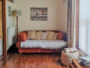 a couch sitting in a living room with a red lighthouse at Elm Barn Lodge in Southampton