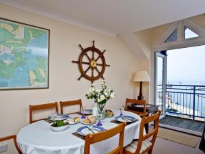a dining room with a table and a large window at 52 Moorings Reach in Brixham