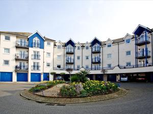 a large apartment building with a flower bed in front of it at 52 Moorings Reach in Brixham