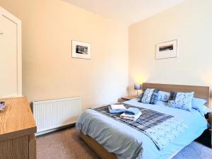 a bedroom with a bed with blue pillows at Ardgay in Fort Augustus