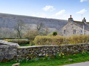 an old stone wall in front of a stone house at Foss Gill in Starbotton
