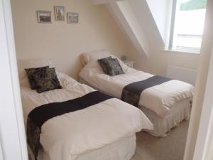 two beds in a small room with a window at Holy Waters in Staveley