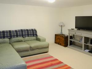 a living room with a couch and a flat screen tv at The Fish House in Rispond