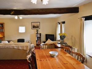a living room with a wooden table and a bedroom at Moorland Retreat in Barbrook