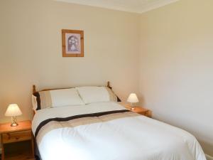 Beeston Saint LawrenceにあるMill Viewのベッドルーム1室(白いベッド1台、ランプ2つ付)