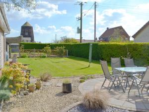 a patio with a table and chairs in a yard at Mill View in Beeston Saint Lawrence