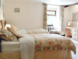 a bedroom with two beds and a window at Forget Me Not Cottage in New Radnor