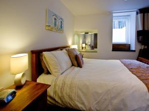 Devon Villa Garden Apartment tesisinde bir odada yatak veya yataklar